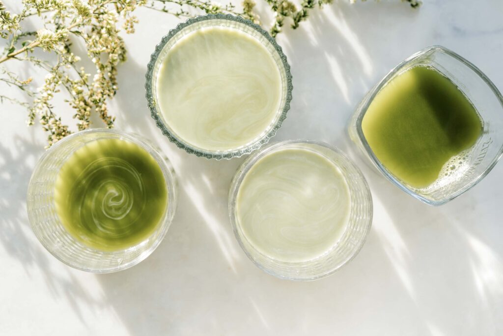 green tea types, including matcha in glass cups on a countertop.