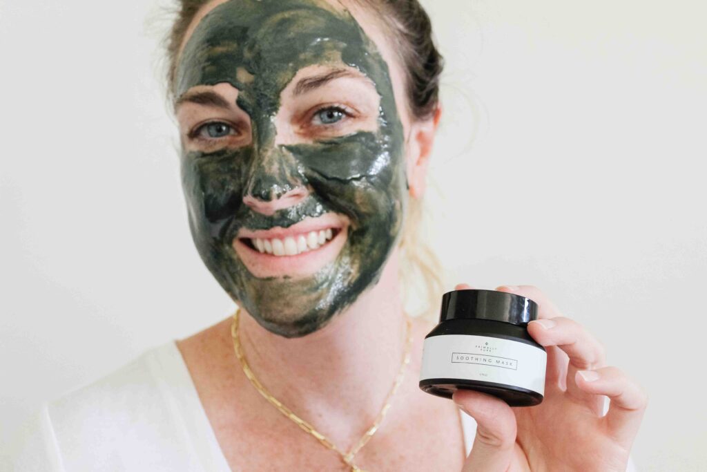 Woman with green primally pure soothing face mask on face