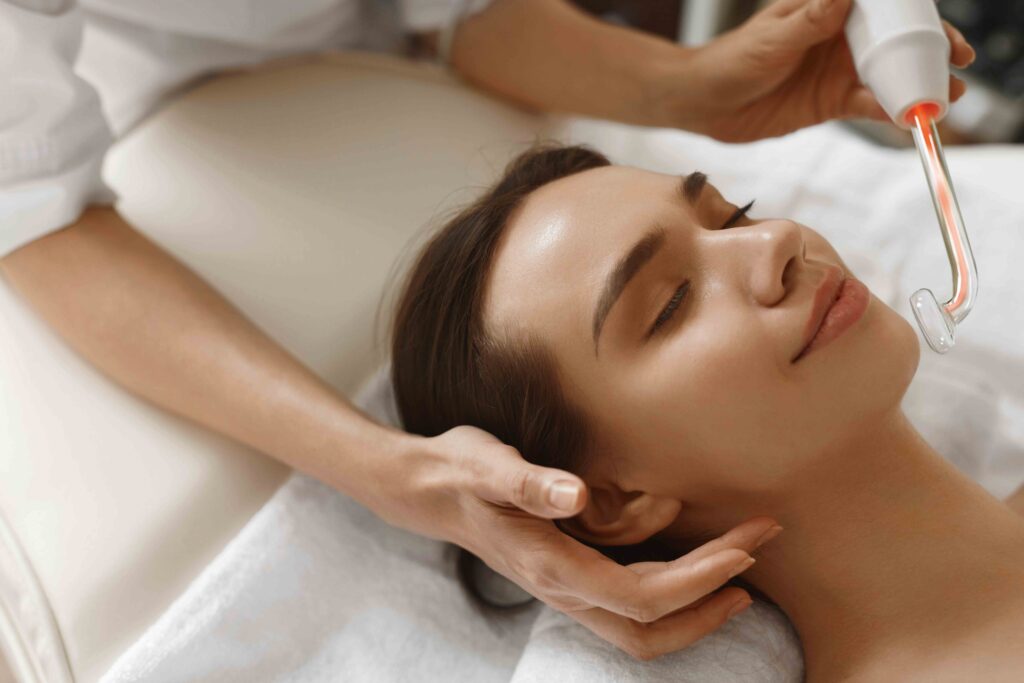 woman on table at spa recieving a high frequency facial