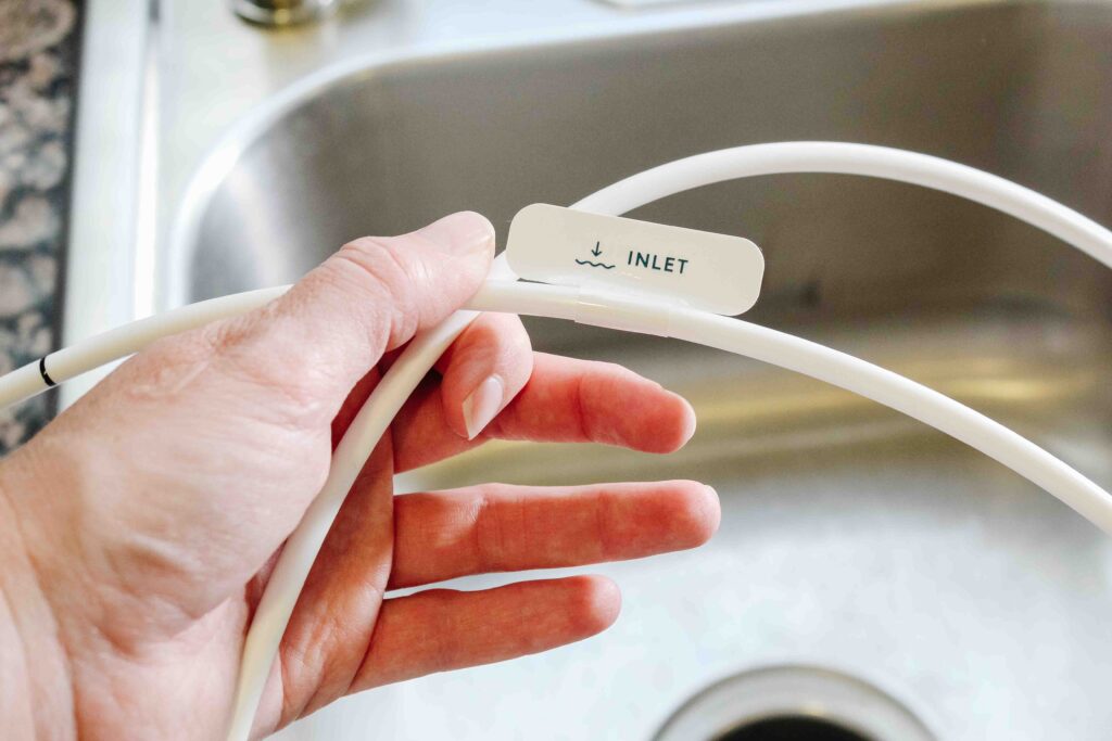 hand holding labeled tubing for fluoride water filter system