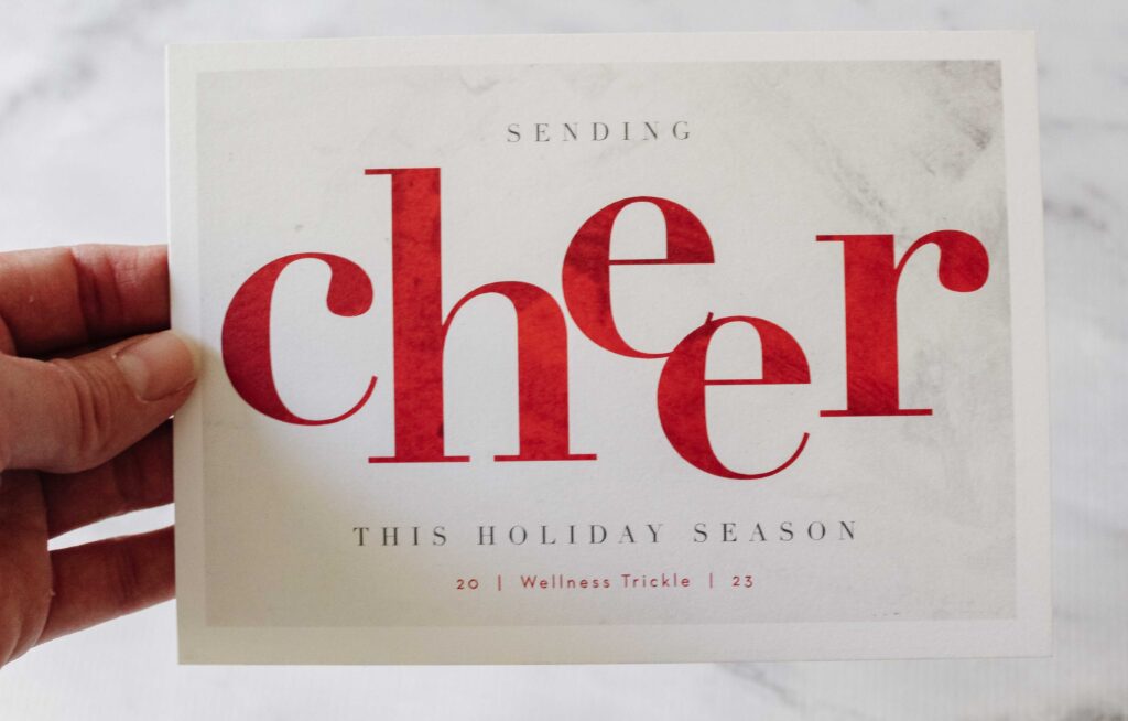 A business holiday card with the word cheer written in red.