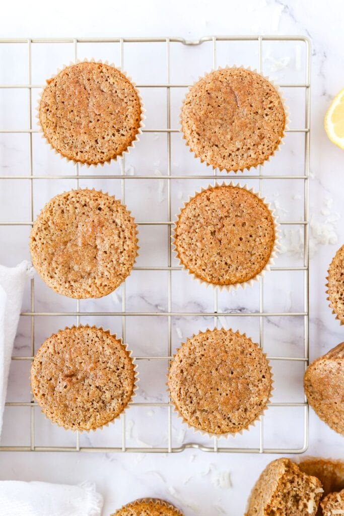 Gluten free lemon muffins on a wire cooling rack on the counter.
