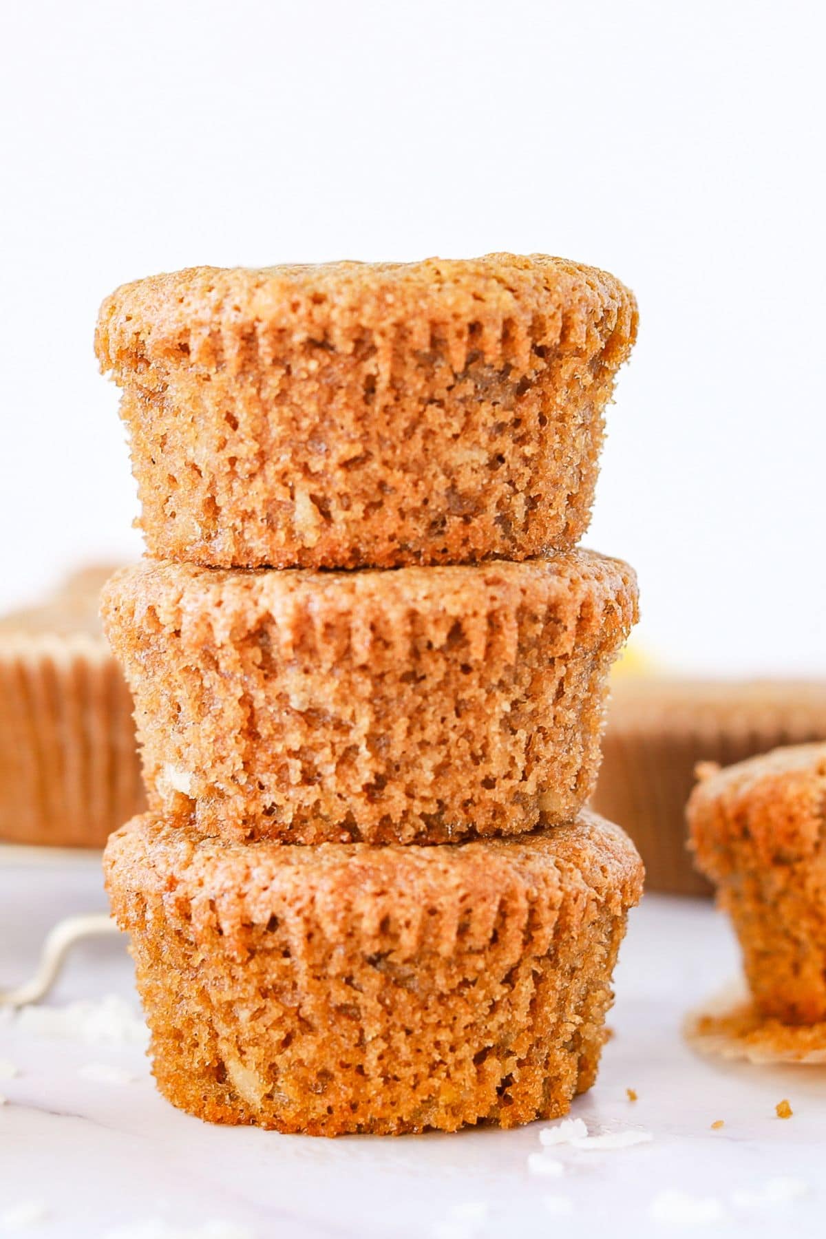 Stacked gluten free lemon muffins on counter.