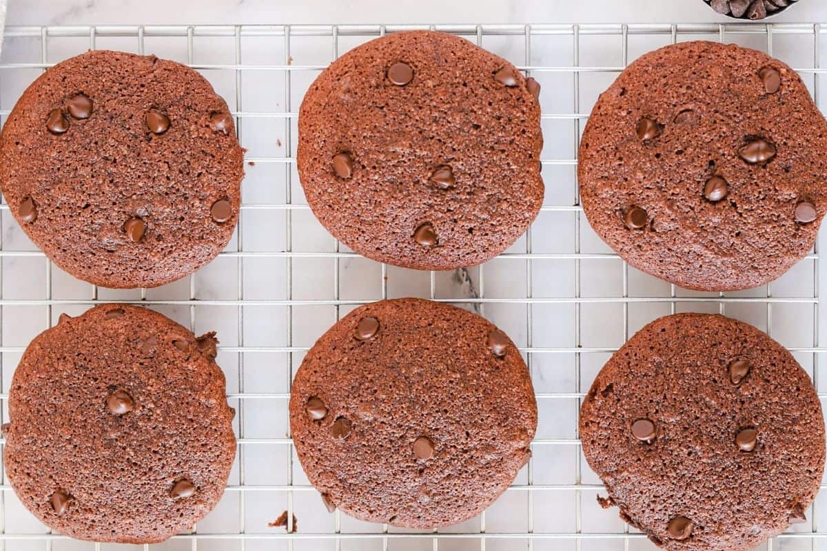 Gluten free double chocolate chip cookies cooling on a wire rack.