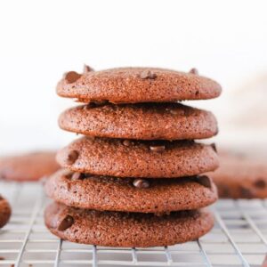 Five gluten free double chocolate chip cookies stacked to show the soft texture.