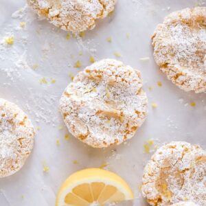 Gluten free lemon cookies on parchment paper with a lemon slice.