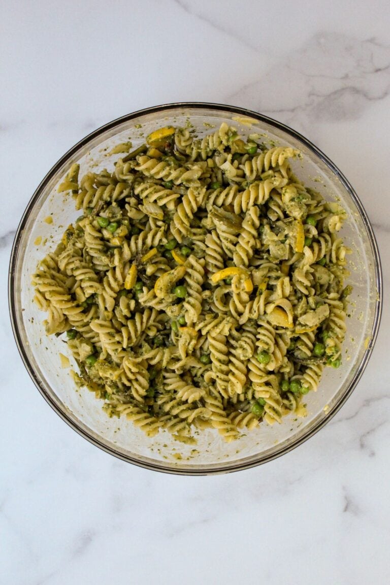 Gluten free pesto pasta salad in a large glass bowl on the counter.